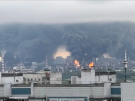 Ukraine Launches Largest Ever Drone Attack on Moscow, Damaging Key Oil Refinery Thick, towering plumes of industrial black smoke rising rapidly over city apartment blocks from a compromised energy complex.
